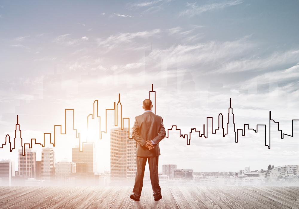 Man looking out over a city skyline, envisioning what's ahead